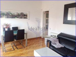 A luminous 75 m2 apartment in Barcelona with black leather furniture and a picture on the wall.
