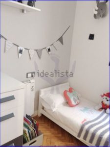 Luminous child's room with a bed, teddy bears, and a toy.