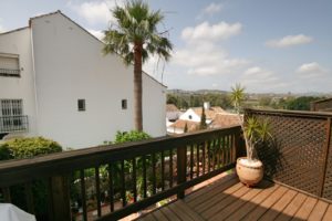 A wooden deck with a palm tree in a semi detached Villa near Alicante.