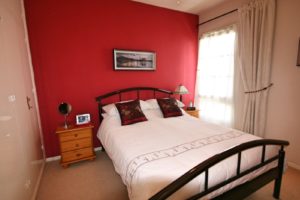 A semi-detached villa near Alicante featuring a bed in a bedroom with red walls.