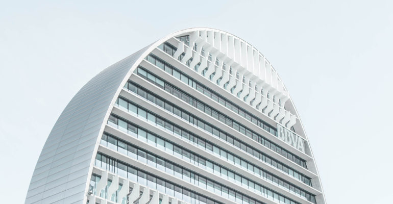 A white building, suitable for real estate investments, with a curved shape.