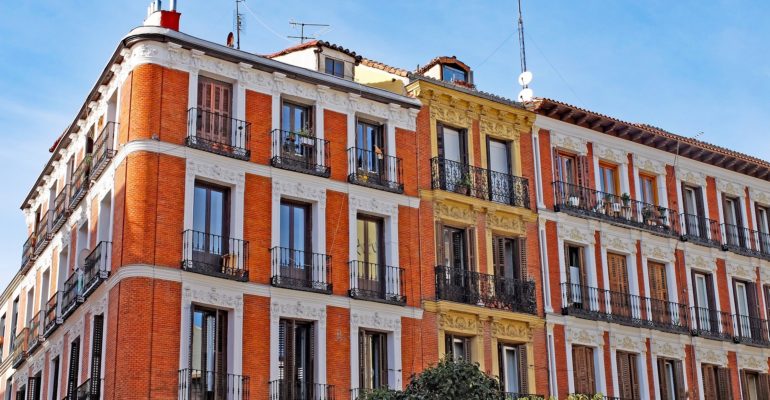 An apartment building in Madrid with balconies, attracting foreign investors to the real estate market.