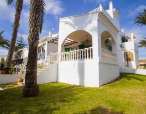 Semi detached white villa near Alicante with palm trees.