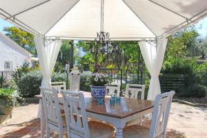 A detached villa near Alhaurín el Grande on the market with an outdoor dining area featuring a white table and chairs for €549.000.