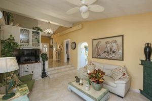 A detached villa near Alhaurín el Grande with yellow walls and a ceiling fan, on the market for €549.000.
