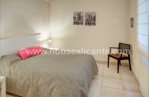 An apartment in the center of Alicante with a bedroom and furnishings.