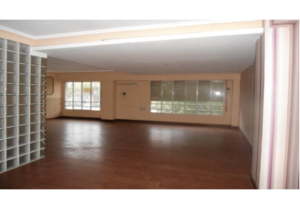 An empty room with shelves and a window, available at less than 1000€/m2 in the centre of Valencia.