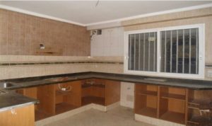 An spacious kitchen with a stove and sink, centrally located in Valencia at an affordable rate.