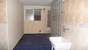 A small bathroom with blue tiles and a sink available in the centre of Valencia at an affordable price.