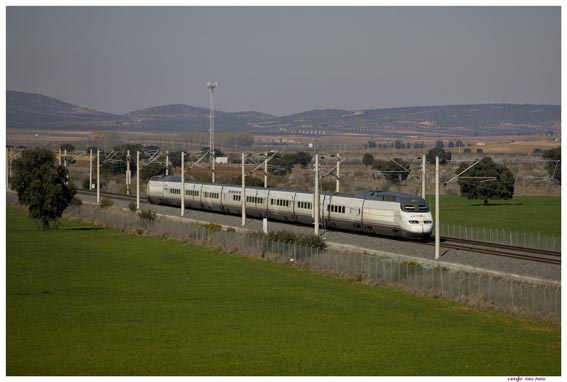 A fast train from Spain traveling down a track in a field after 25 years.