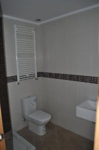 A tiled bathroom with a toilet and sink.