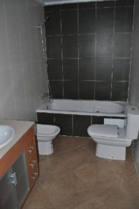 A bathroom with a toilet, sink and tub.