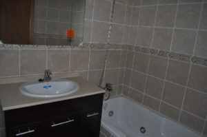 A bathroom with tiled walls and a sink.