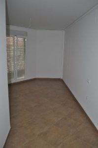 An empty room with a tile floor and sliding doors.