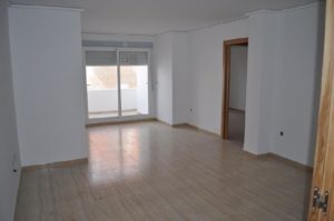 An empty room with wooden floors and a sliding door.