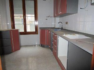 99 m2 apartment with a kitchen featuring red and grey cabinets and a window, located in San Sebastian.