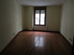 An LAREDO apartment with wooden floors and a window.