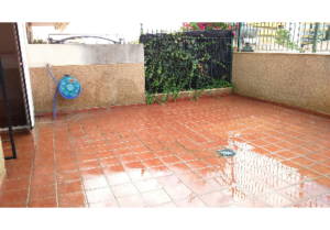 A 76m2 + 37m2, two-bedroom apartment in Malaga-FUENGIROLA with a patio featuring a red tiled floor and fence.