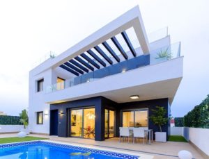 A modern villa for sale in Villamartín - Orihuela Costa, featuring a swimming pool and patio.