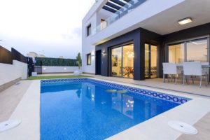 A modern villa for sale in Villamartín - Orihuela Costa with a swimming pool and patio.