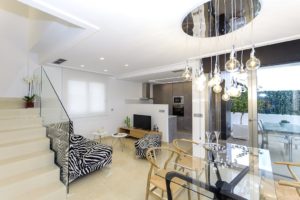 A modern living room with a glass staircase in a villa for sale in Villamartín - Orihuela Costa.