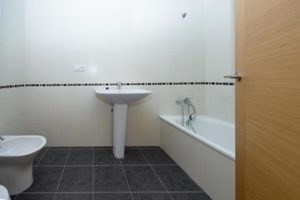 A newbuilding bathroom on the market for a little more than 600€, equipped with a toilet, sink, and shower.