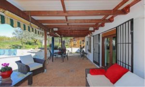 A Detached Villa for sale in Coín featuring a patio with furniture and a swimming pool.