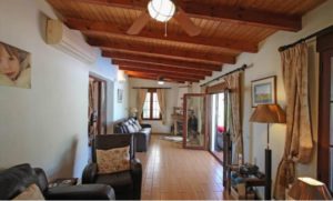 Detached Villa for sale in Coín with a living room featuring wooden floors and a ceiling fan.