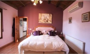 A detached villa for sale in Coín with a bed or beds in a room at person's house.