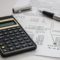 A calculator sits on top of a piece of paper, calculating the cost of owning Spanish property.