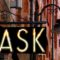 A sign on a building displaying prompt to "ask.