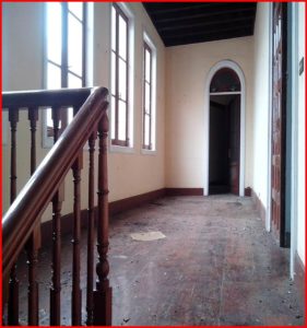 A magnificent manor in Tenerife with a grand staircase and wooden floors, needing some repair.