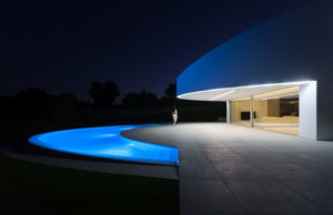 A modern dream house in Spain, architecturally designed with a beautiful swimming pool, set against the enchanting nighttime backdrop