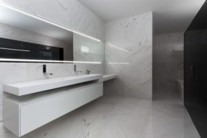 A dream house in Spain featuring a white and black bathroom with marble counter tops.