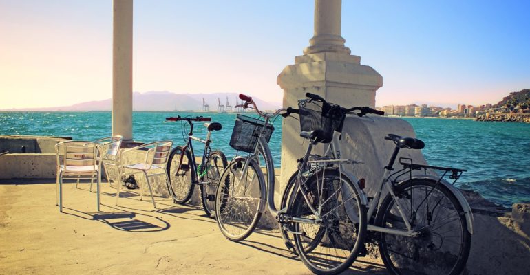 A row of bicycles parked on a waterfront pier.