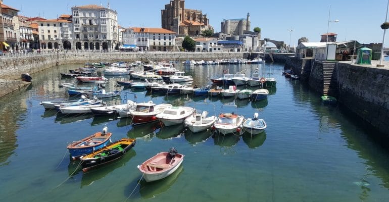 Boats docked in a harbor near a city with Spanish property transactions.