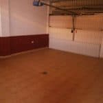 Empty garage with tiled floors and a garage door, located in a bank property: Terraced house in Tenerife.