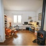 A detached villa for sale in Tolox, featuring a room with a wood burning stove and a desk.