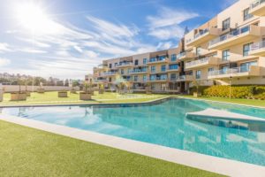A luxury apartment complex in Costa Blanca South with a swimming pool and lawn area.