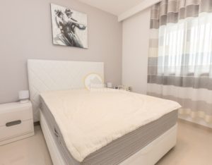 A luxury Costa Blanca South apartment in La Zenia featuring a white bed and dresser.