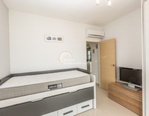 A luxury apartment in La Zenia on the Costa Blanca South, featuring a small bedroom with a bed and a TV.