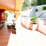 A detached villa in Mijas Costa with a patio area featuring a sofa and a fireplace.