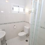 A detached villa in Mijas Costa with a bathroom comprising a toilet, sink, and shower.