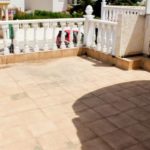 A Villamartin townhouse with a balcony featuring a table and chairs, satellite dish, and priced below 100.000€ in Orihuela Costa.