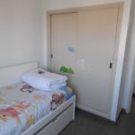 A beautiful apartment in Los Cristianos, Tenerife with a small bedroom featuring a bed and a closet.