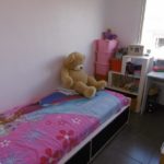A small Los Cristianos bedroom with a teddy bear on the bed.