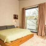 A detached villa in Girona with a bed and a clock on the wall.
