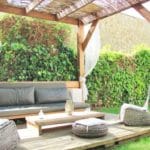 Detached Villa in Girona with a wooden pergola and wicker furniture.