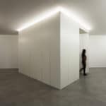 A person walks through a white office undergoing renovations in Spain.