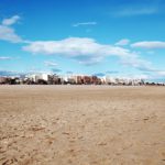Buildings on a sandy beach in Valencia, offering opportunities in the real estate market.